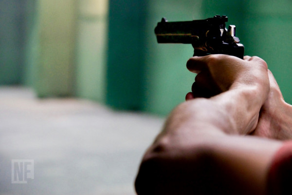 Homen apontando arma de fogo