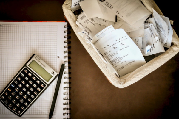 Calculadora ao lado de notas fiscais