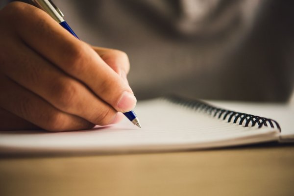 Estudante escrevendo no caderno