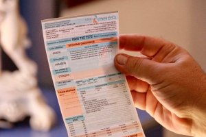 Pessoa segurando boleto com a conta de energia