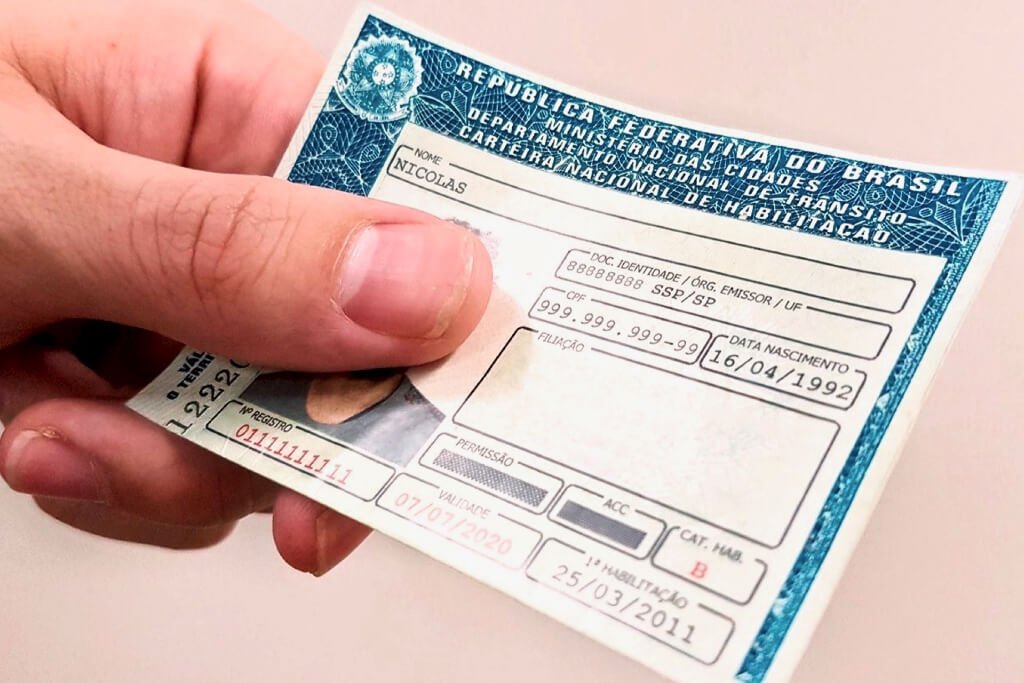 Pessoa segurando carteira de habilitação (CNH)