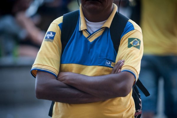 Trabalhador dos Correios de braços cruzados