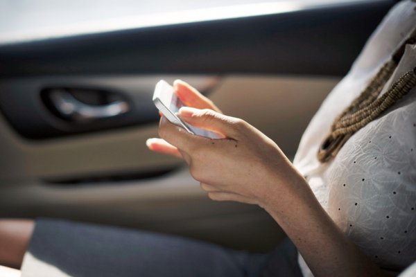 Mulher manuseando um smartphone com as duas mãos
