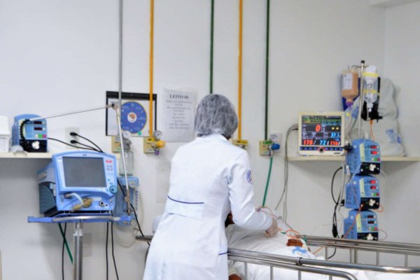 Enfermeira checando aparelho respiratório em hospital