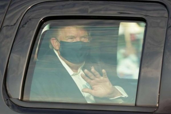 Trump dentro do carro usando máscara
