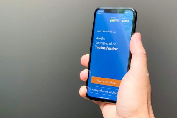 Pessoa segurando celular exibindo na tela o Aplicativo Auxílio Emergencial ao Trabalhador, da Caixa