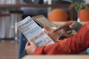 Consumidor segurando uma conta de luz na mão esquerda