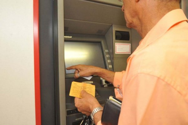 Aposentado sacando benefício no caixa eletrônico