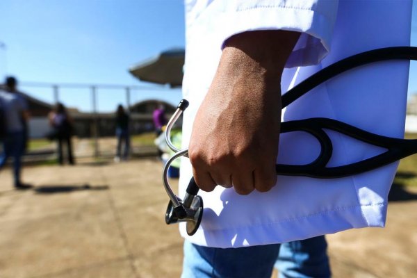 Profissional da medicina segurando um estetoscópio na mão esquerda