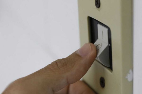 Polegar de uma pessoa acionando o interruptor de energia