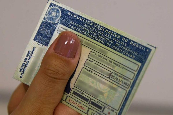 Dedo polegar segurando uma CNH