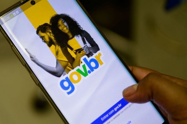 Pessoa segurando celular, exibindo a plataforma Gov.br
