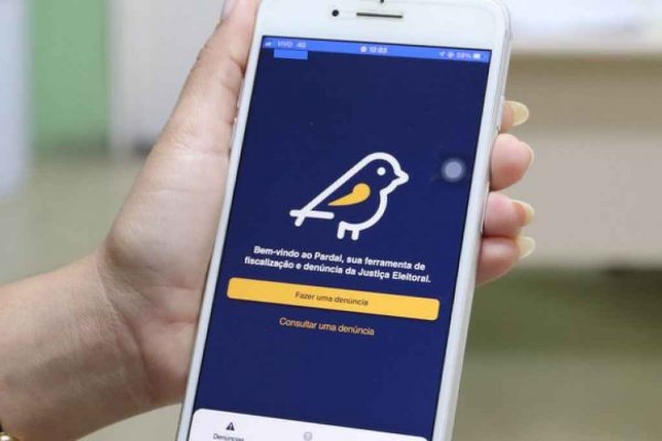 Pessoal segurando smartphone, exibindo o Aplicativo Pardal, da Justiça Eleitoral, onde são feitas denúncias de propaganda eleitoral irregular
