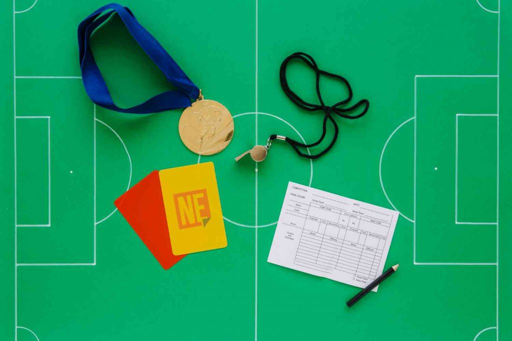 Ilustração representando um campo de futebol, com cartões vermelho e amarelo.