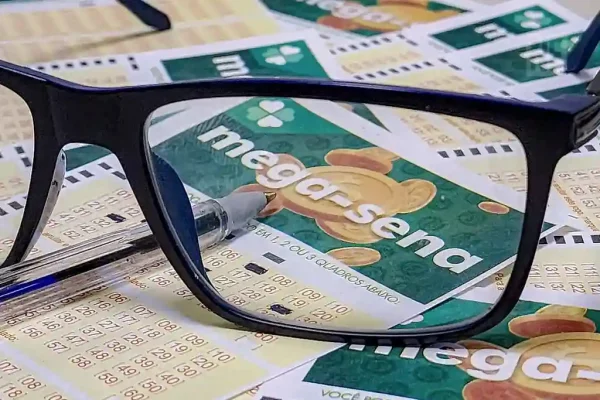 Óculos e caneta sobre bilhete da Mega-Sena