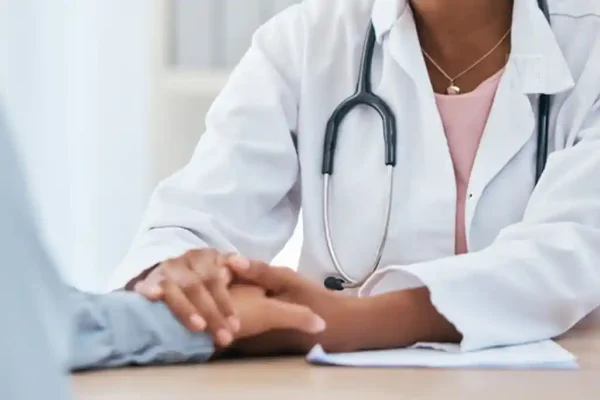 Médica segurando a mão de uma paciente