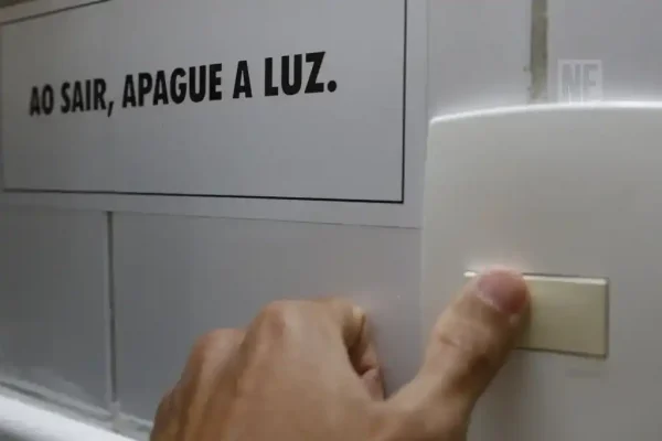 Pessoa acionando o interruptor de apagar a luz