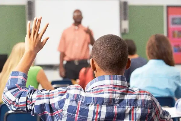 Estudante em primeiro plano e professor negro na sala de aula