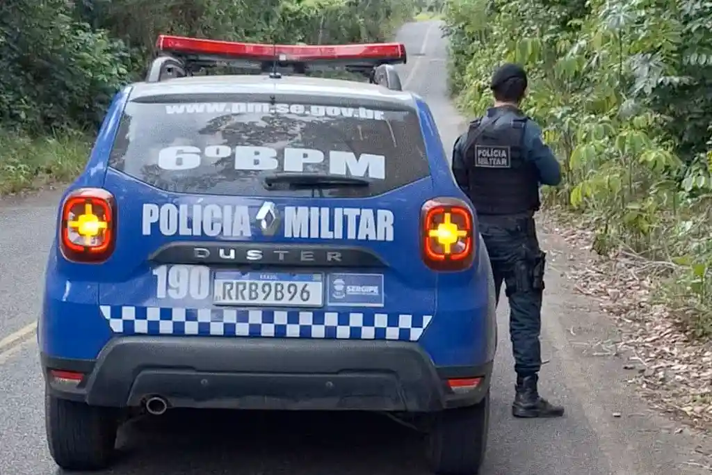 Policial ao lado da viatura do 6º Batalhão (6º BPM), da PMSE
