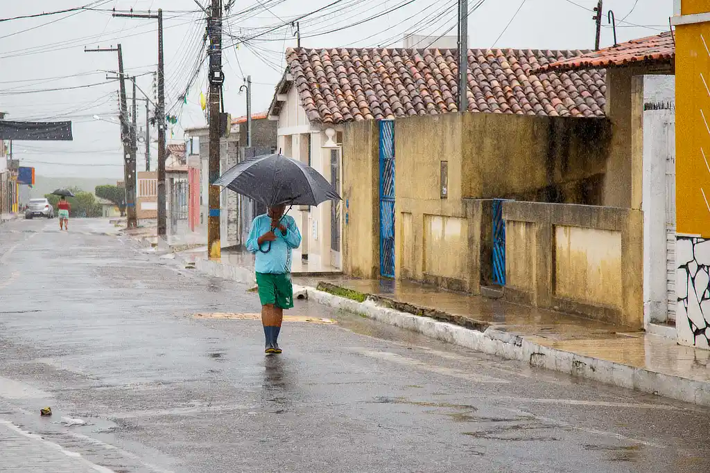 Homem caminha sob chuva no interior de Sergipe