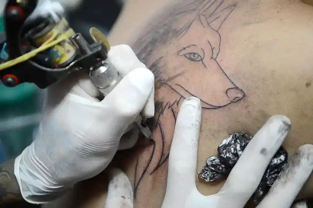Tatuador fazendo tatuagem de um cachorro