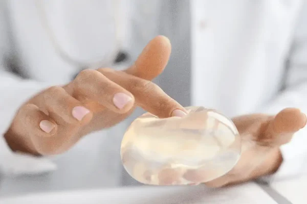 Prótese mamária na mão de médica-cirurgiã