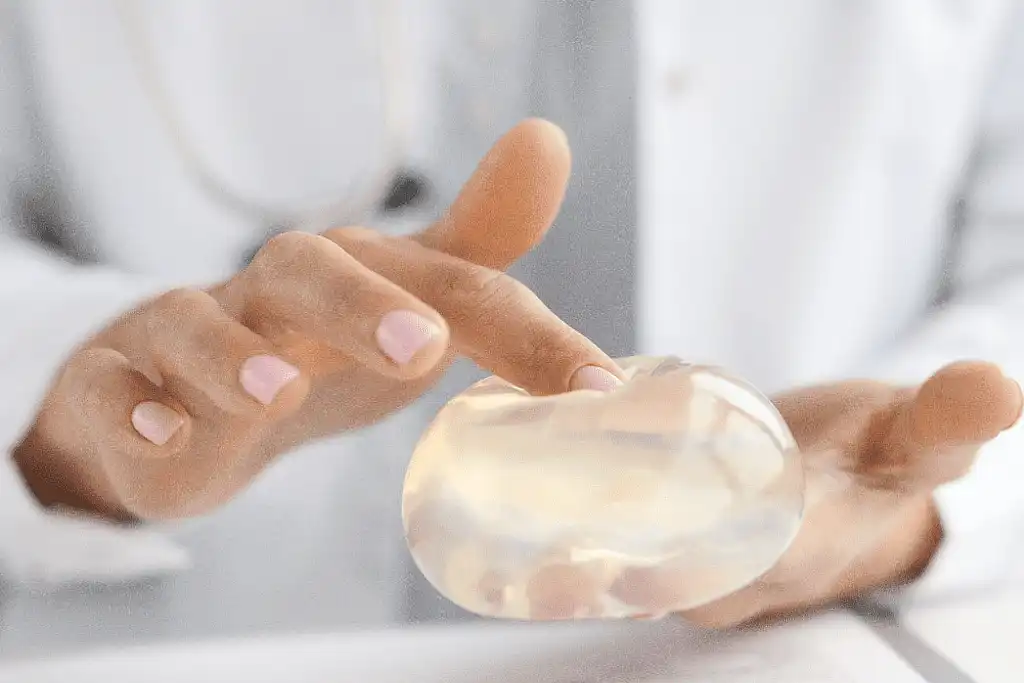 Prótese mamária na mão de médica-cirurgiã