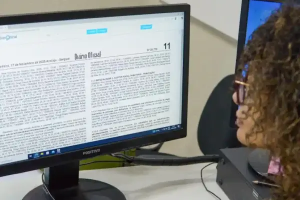 Mulher olhando para monitor com o Diário Oficial do Estado de Sergipe na tela