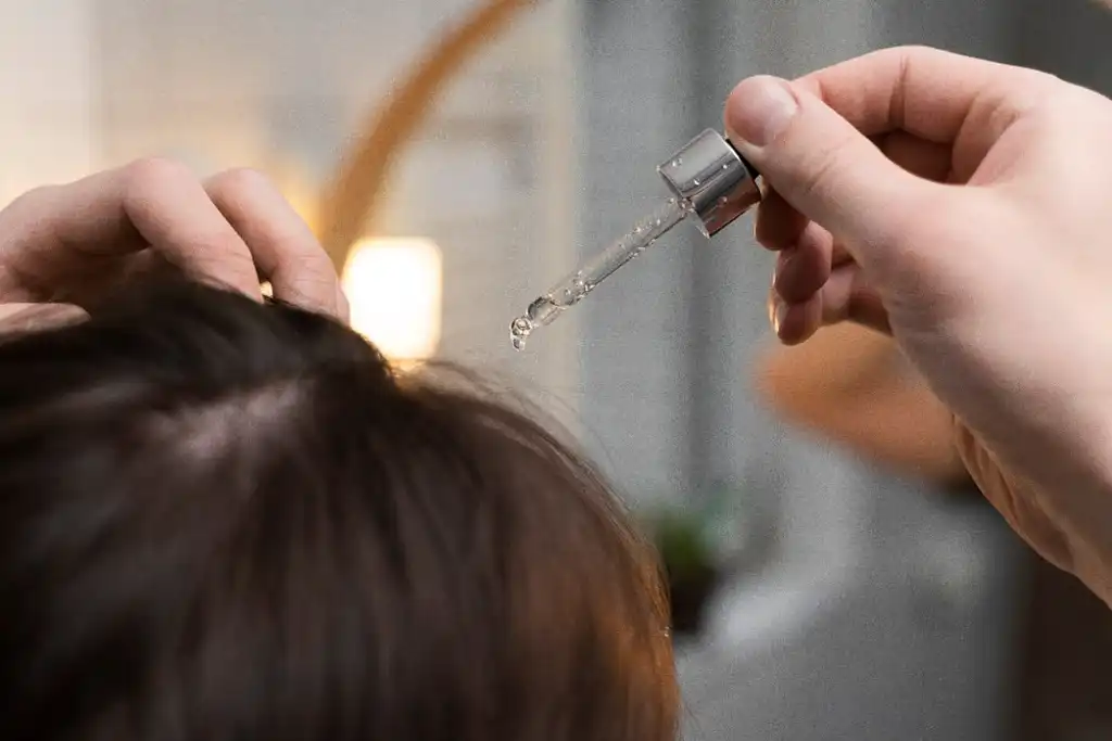 Tônico capilar sendo aplicado no couro cabeludo
