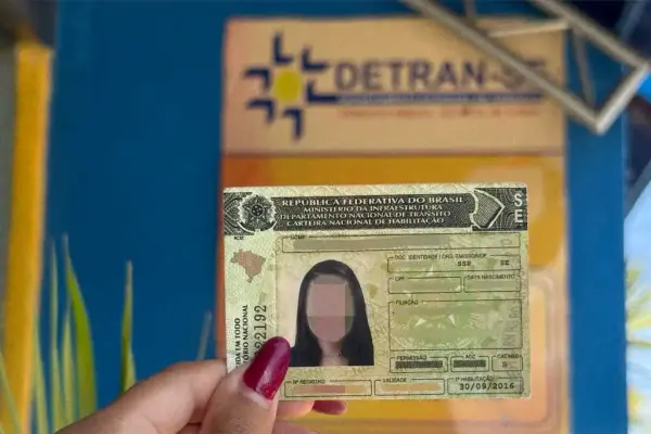 Mulher segurando CNH no Detran Sergipe