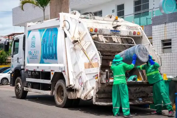 Caminhão e trabalhadores da limpeza coletando lixo nas ruas de Aracaju