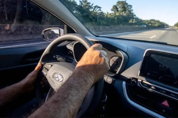 Motorista conduzindo um carro em uma rodovia