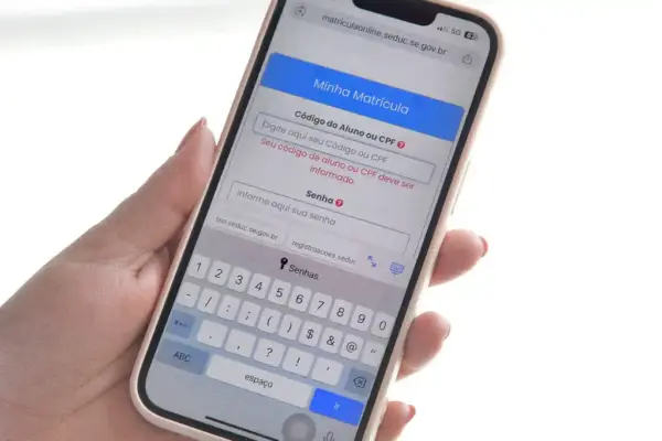 Mulher segurando celular com a mão esquerda exibindo o Portal Matrícula Online