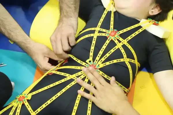 Paciente durante tratamento pelo Método TREINI, utilizando um exoesqueleto flexível (veste Treini Exoflex)