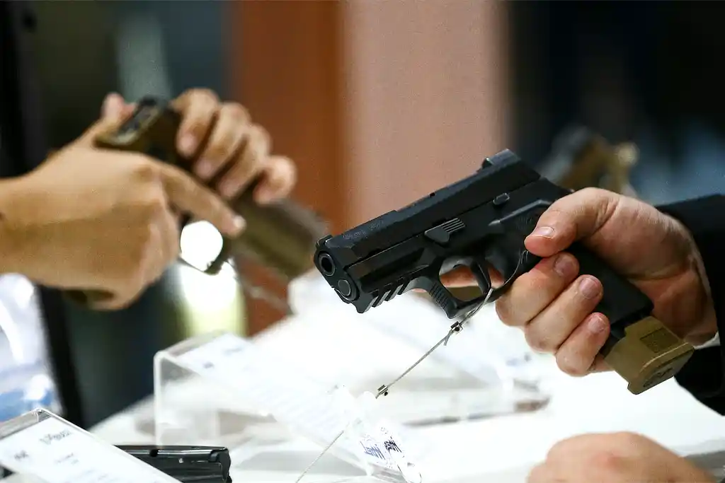 PF faz busca em Itabaiana por registro CAC irregular 1 Pessoas manuseando armas em evento do segmento de defesa e segurança, no Distrito Federal